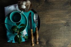 Top view of Easter table setting with teal plates and blue decorative eggs