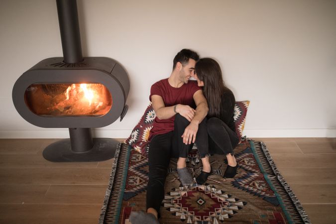 Couple sitting near fireplace on floor