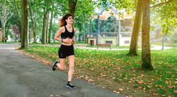 Female athlete running through a park