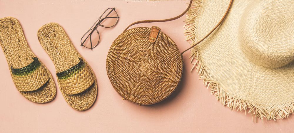 Sandals, glasses, bag, straw hat on pink background, wide composition