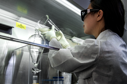 Female scientist pouring liquid from a beaker