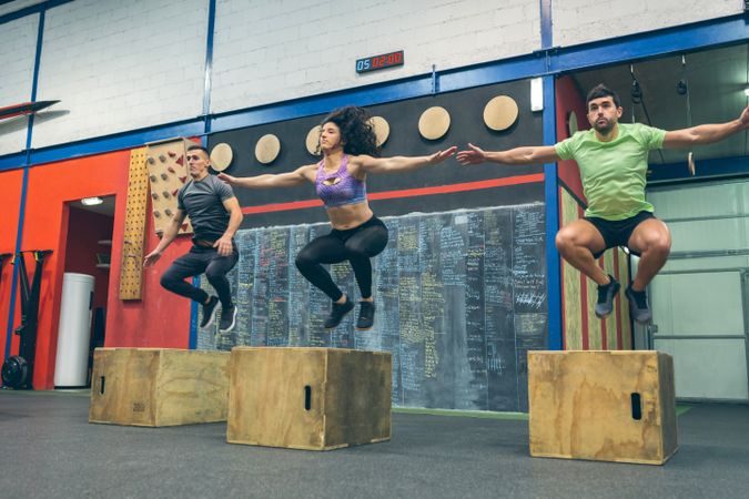 Athletes exercising jumping wooden box