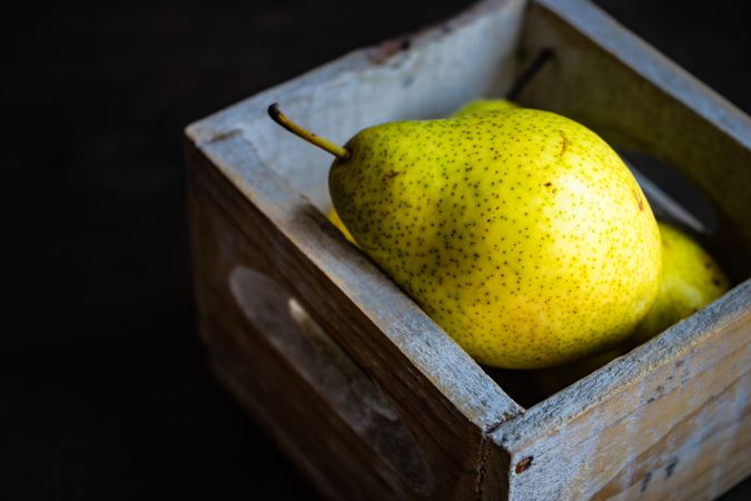 Organic ripe pear fruit in wooden box