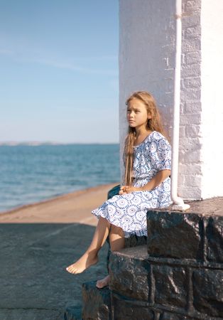 Girl by the sea with white pillar
