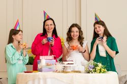 Family wearing festive hats celebrates a birthday together