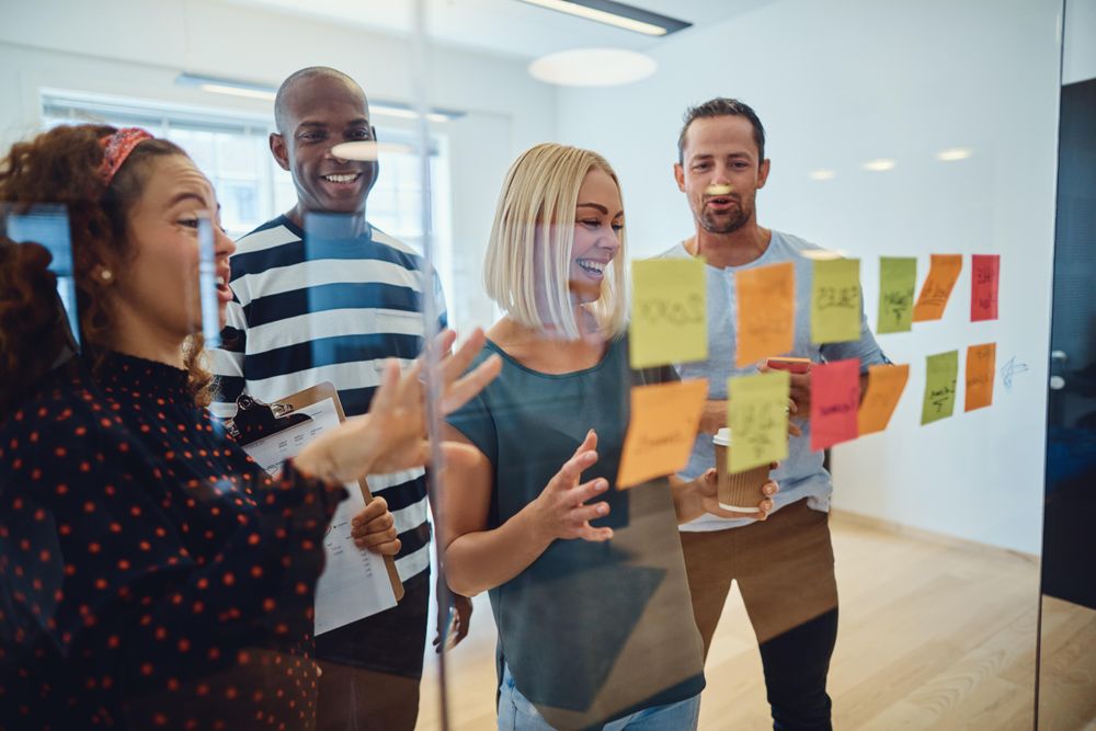 Group of people working with sticky notes in a bright office