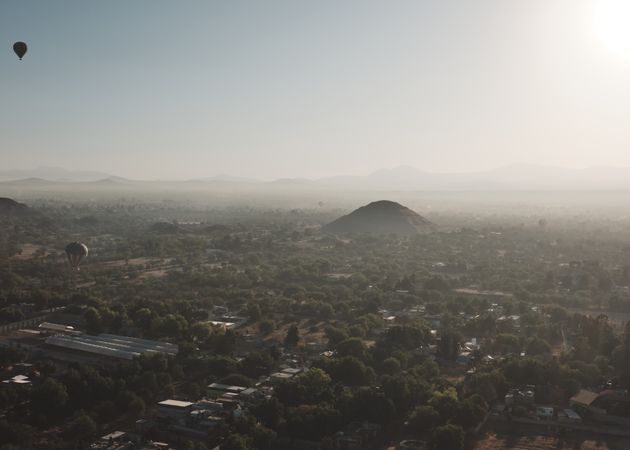 Hot air balloons flying above hazy morning in Teotihuacan Valley