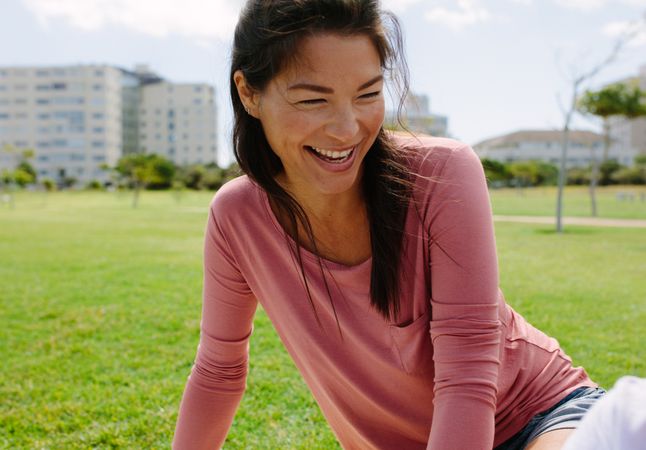 Close up of a smiling woman sitting in a park