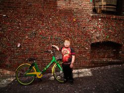 Six-year-old Gregorio Drozco III at the gum wall with a green bike, Seattle, Washington 0yXq1b