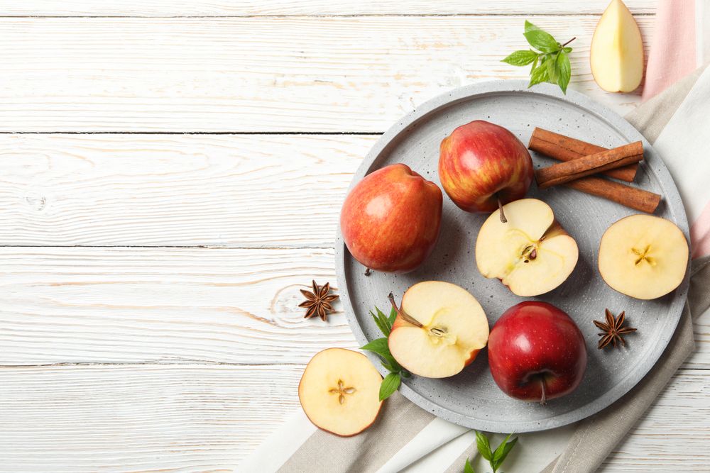 Looking down at plate of apples, anise and cinnamon sticks, with copy space