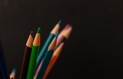Multi colored pencils on dark background