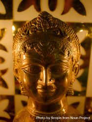 Close-up shot of golden Buddha statue in a candle lit room 0vARxb