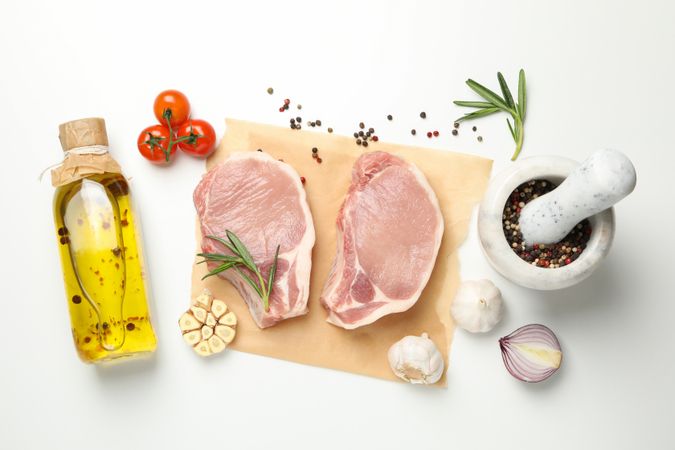 Composition with raw meat and ingredients on light background, top view