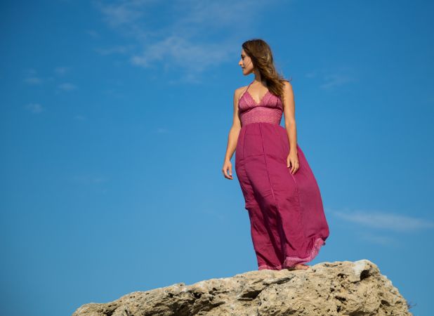 Woman in dress standing near stone monument