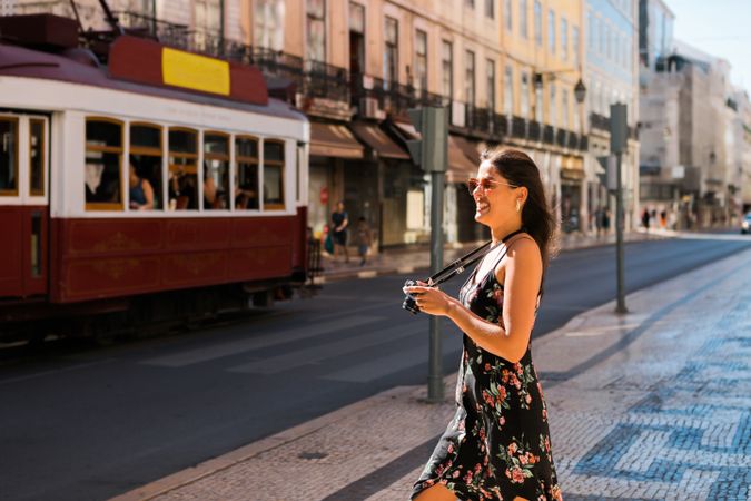 Woman holding a camera while standing on street