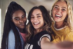 Happy group of young women taking a selfie with camera