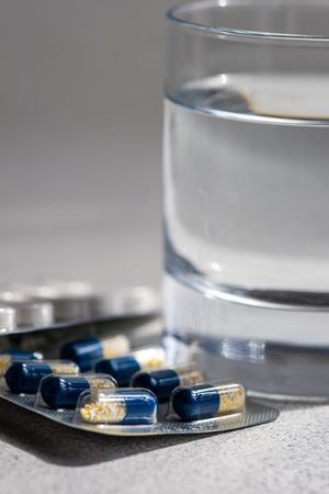 Side view of pills and glass of water