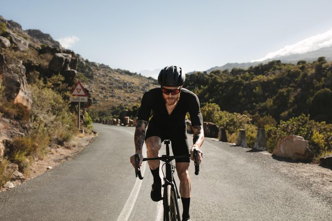 Professional bicycle rider doing uphill ride on mountain road