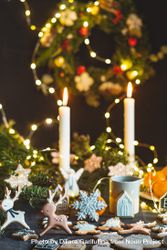 Candle-lit Christmas table with cookies, lights, and wreath 5qNGj4