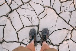 Looking down on boots on dry earth