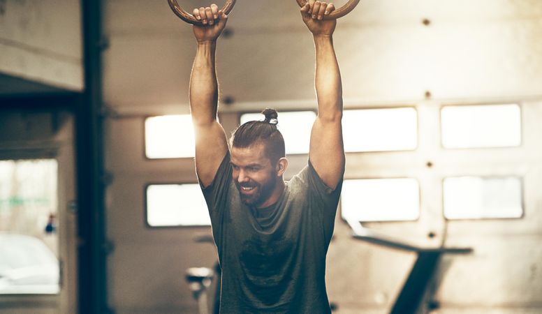 Man holding rings in gym