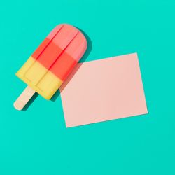 Ice cream popsicle with pink paper card note on vivid blue background