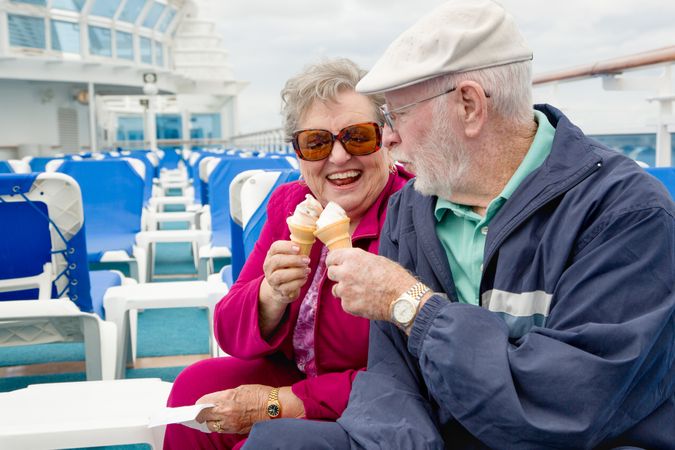 Happy Older Adult Couple Enjoying Ice Cream On The Deck of a Luxury Passenger Cruise Ship.