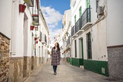Happy female strolling on empty narrow street