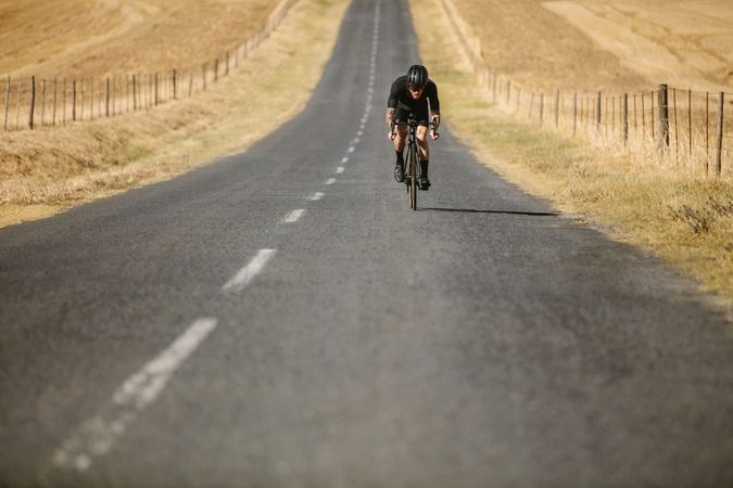 Sportsman cycling on countryside highway