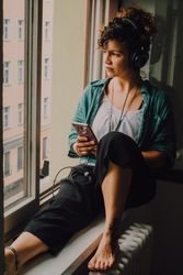 Relaxed woman in headphones using smartphone at home