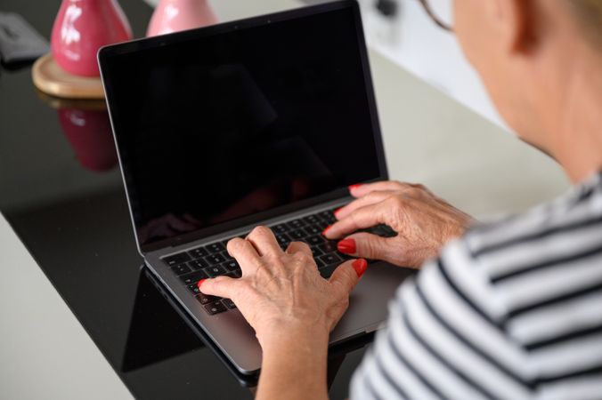 Crop of woman typing on laptop