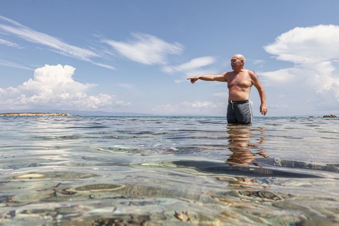 Cheerful man swimming in sea water