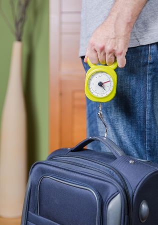 Man checking luggage weight with steelyard balance