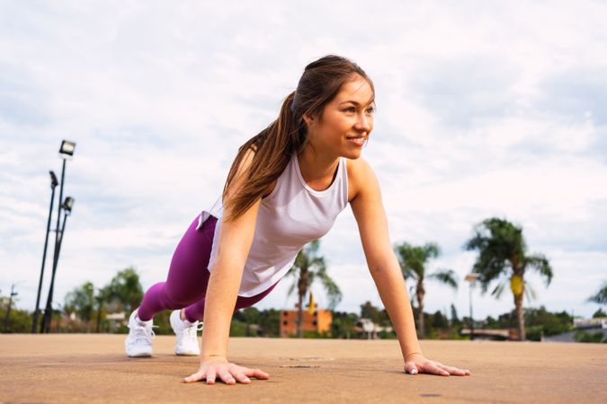 Woman doing press up exercise on sports ground