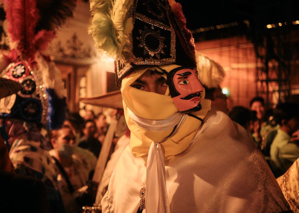 Man with face covered and hat at street carnival