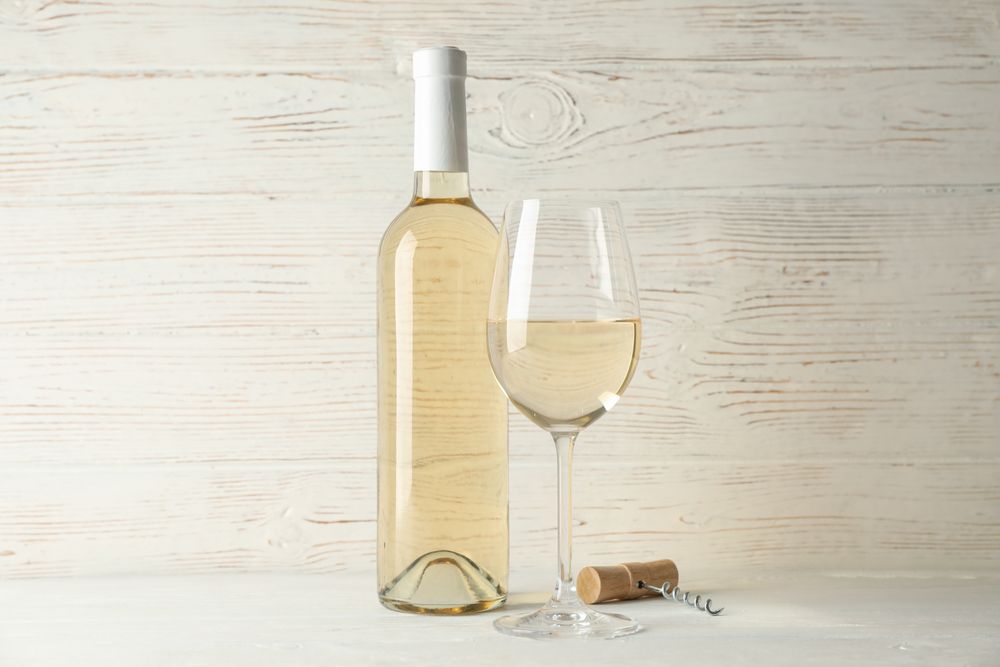 Corkscrew, bottle and glass with wine on blank wooden background, copy space