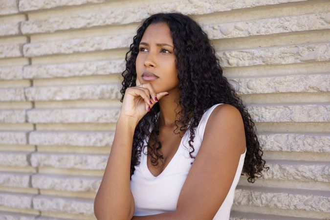 Contemplative Young Woman with Beautiful Curly Hair in a Thoughtful and Reflective Pose