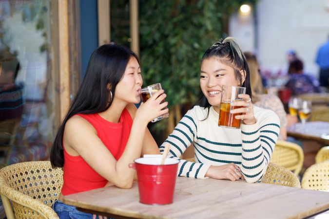 Two women sitting in restaurant patio with drinks