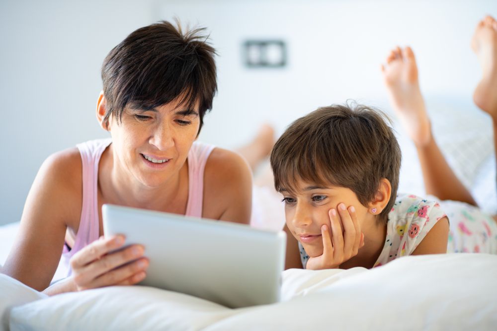 Woman reading to her daughter on tablet