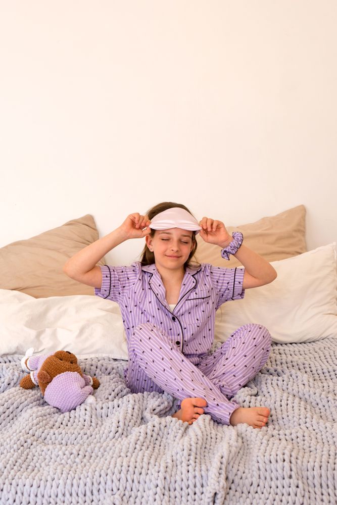 Girl adjusting sleep mask in bed