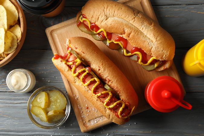 Composition with tasty hot dogs on wooden background, top view