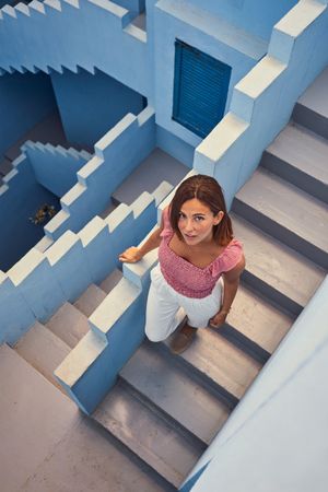 Woman walking downstairs on modern blue building