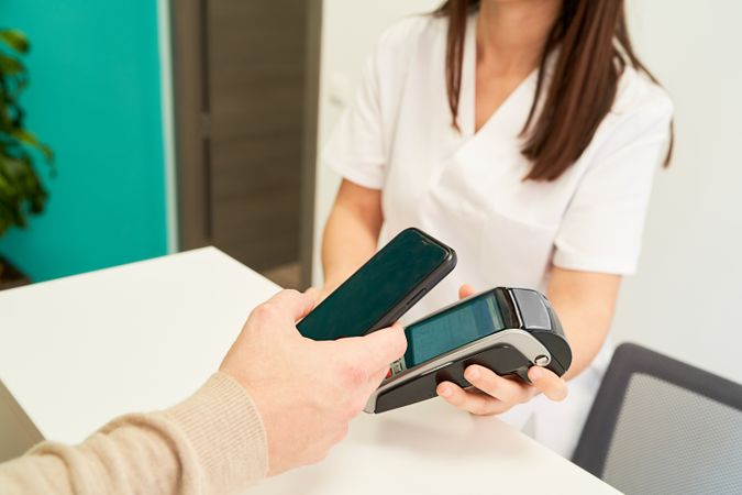 patient paying the visit to the physiotherapist by credit card