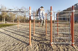 Woman training on parallel bars on street