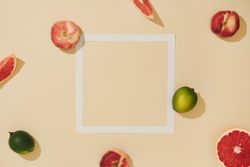 Minimal sunlit fruit composition with sand color background and sharp shadows