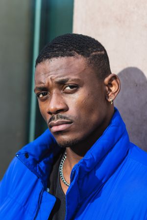 Black stylish man in warm jacket on street
