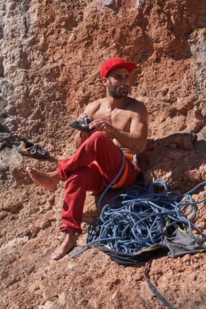 Man with climbing shoes near rock