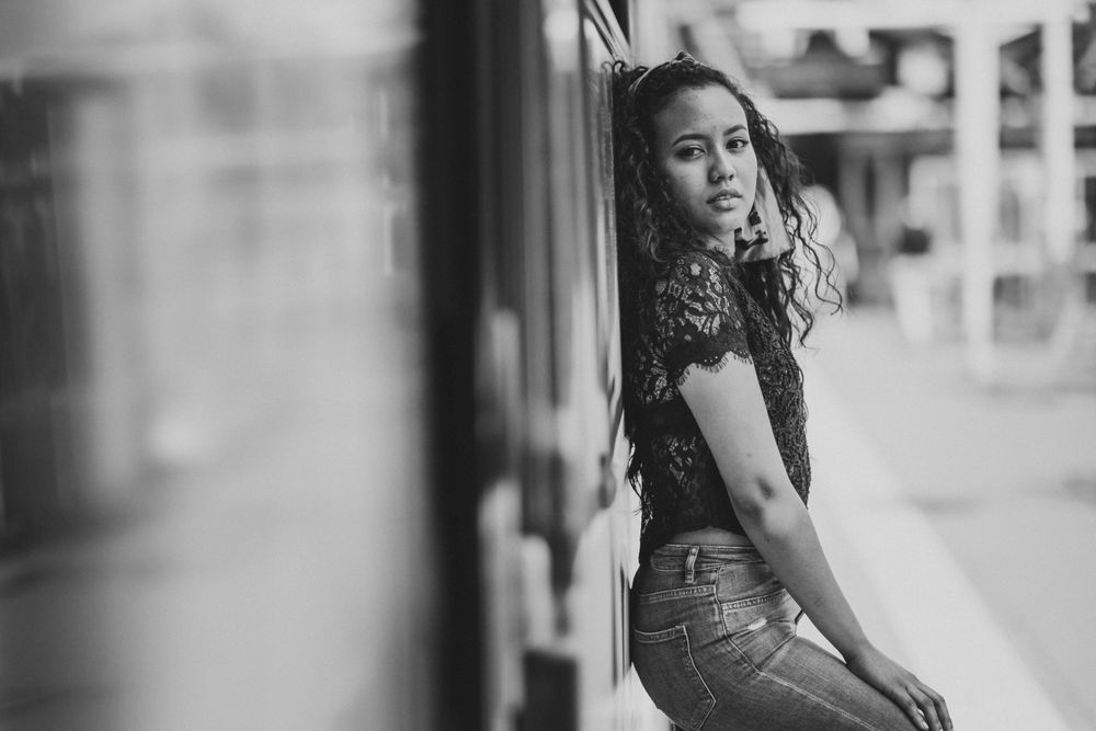 Cheerful hispanic woman standing on train
