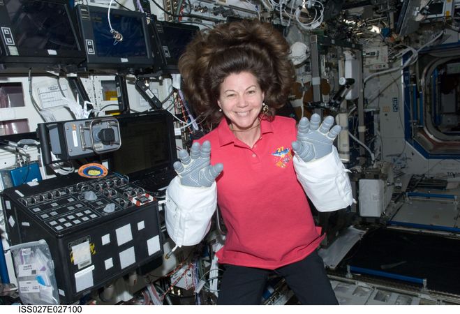 Flight engineer Cady Coleman, wearing Extravehicular Mobility Unit gloves