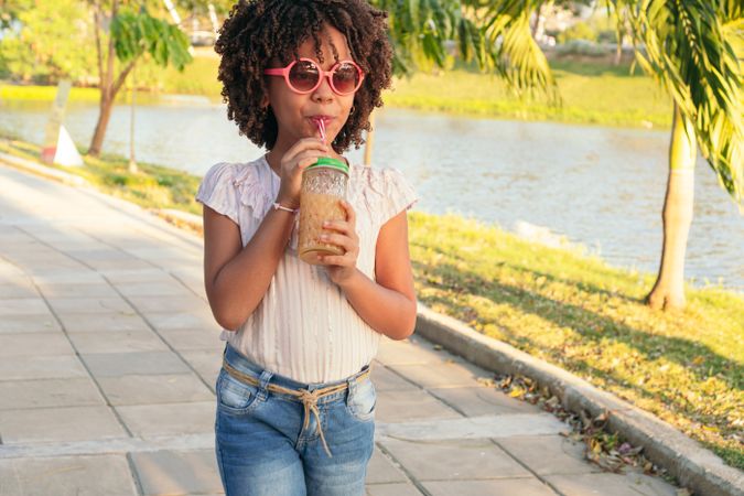 Girl with curly hair walking in park
